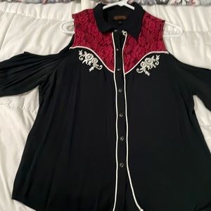 Black cold shoulder long sleeved with pearl snap buttons and red lace .